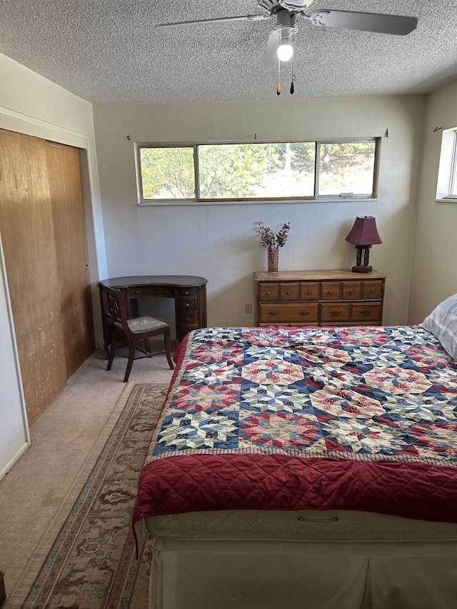 carpeted bedroom featuring ceiling fan, multiple windows, and a textured ceiling