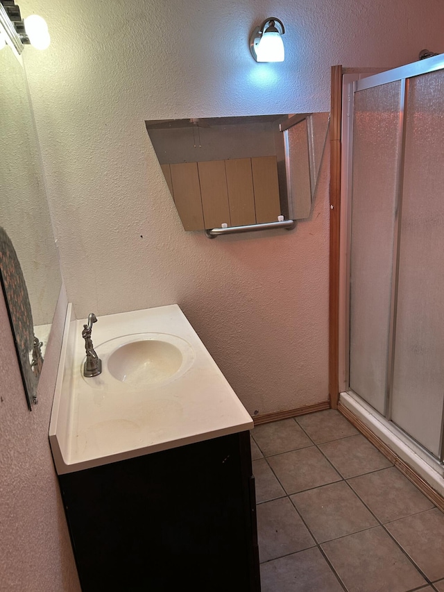 bathroom with tile patterned flooring, vanity, and an enclosed shower