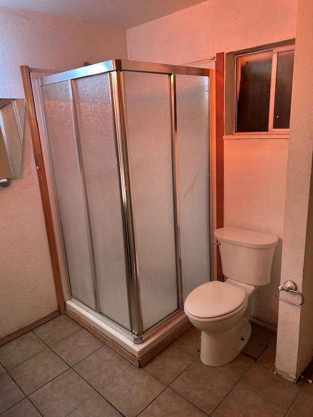 bathroom with walk in shower, tile patterned floors, and toilet