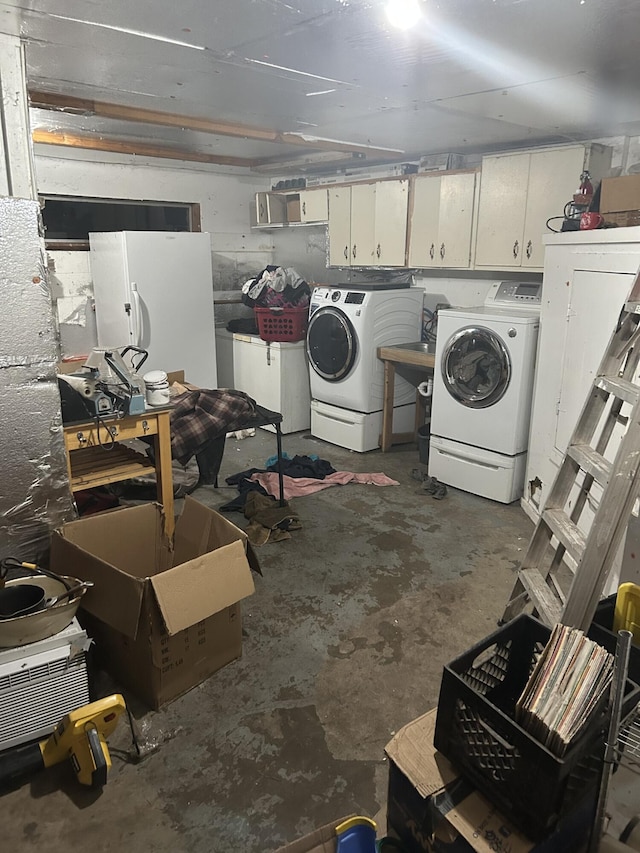 clothes washing area featuring cabinets and separate washer and dryer