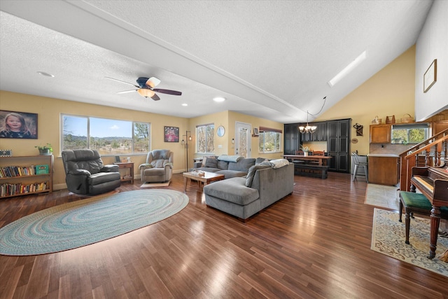 living room with ceiling fan with notable chandelier, high vaulted ceiling, dark hardwood / wood-style floors, and a textured ceiling