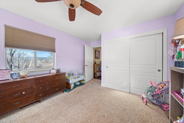 bedroom featuring ceiling fan, a closet, and light carpet