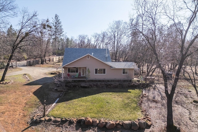 rear view of property featuring a lawn