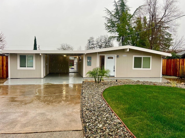 ranch-style house featuring a front lawn and a carport