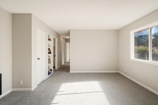 carpeted spare room featuring a textured ceiling