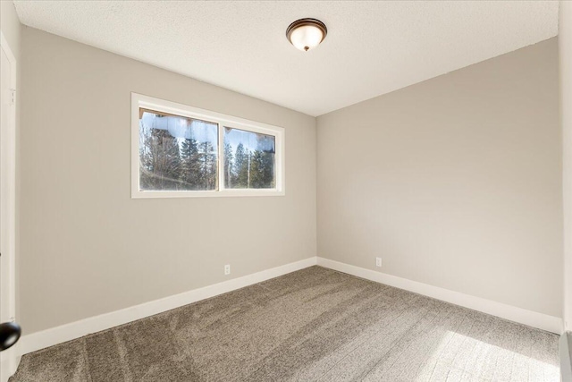 carpeted spare room featuring a textured ceiling