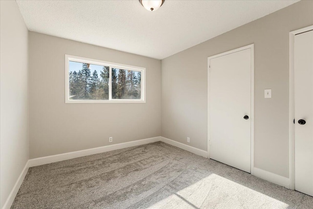 carpeted spare room with a textured ceiling