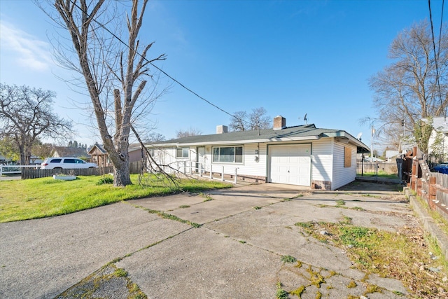 back of house featuring a garage and a lawn