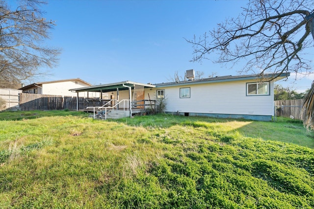 back of property with a wooden deck and a lawn