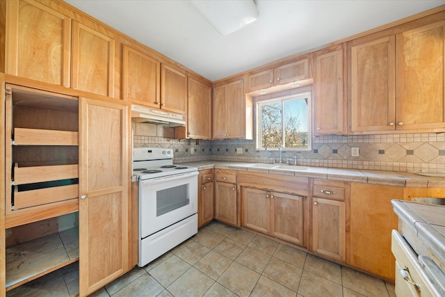 kitchen featuring sink, tile counters, backsplash, and white range with electric stovetop