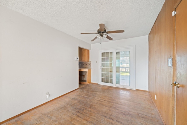 unfurnished room with ceiling fan, a textured ceiling, and light hardwood / wood-style floors