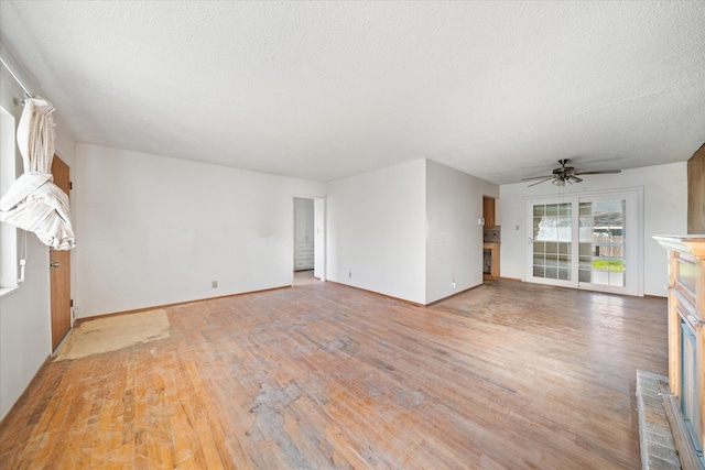 unfurnished living room with hardwood / wood-style flooring, ceiling fan, and a textured ceiling