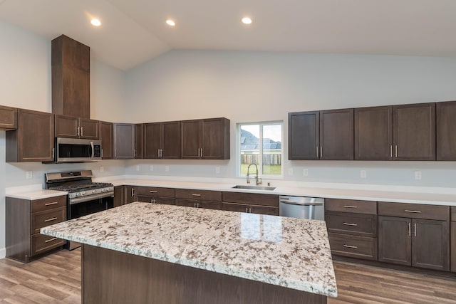 kitchen with dark brown cabinetry, sink, stainless steel appliances, and a center island