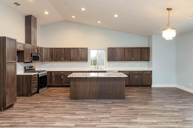 kitchen featuring dark brown cabinetry, stainless steel appliances, sink, and hanging light fixtures