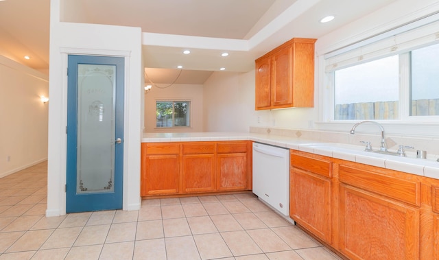 kitchen featuring white dishwasher, sink, light tile patterned floors, and tile countertops