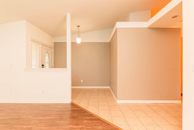 spare room with vaulted ceiling and light tile patterned floors