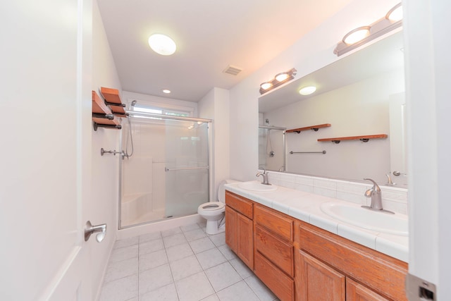 bathroom featuring tile patterned flooring, an enclosed shower, vanity, and toilet