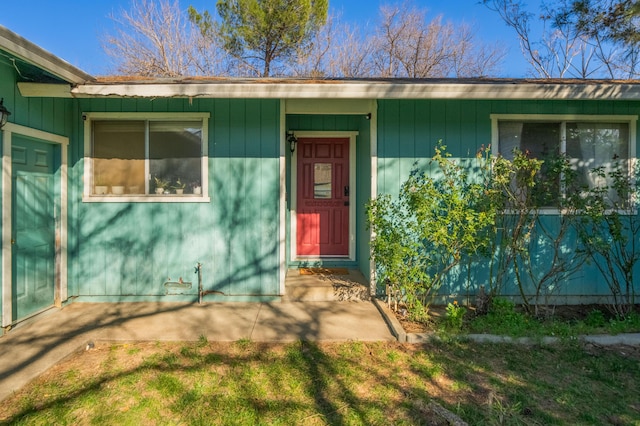 property entrance featuring a lawn