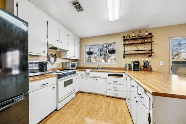 kitchen featuring white appliances, light hardwood / wood-style floors, kitchen peninsula, and white cabinets