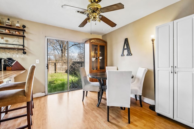 dining area with ceiling fan and light wood-type flooring