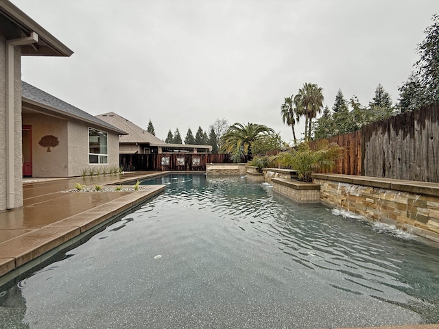 view of swimming pool with pool water feature