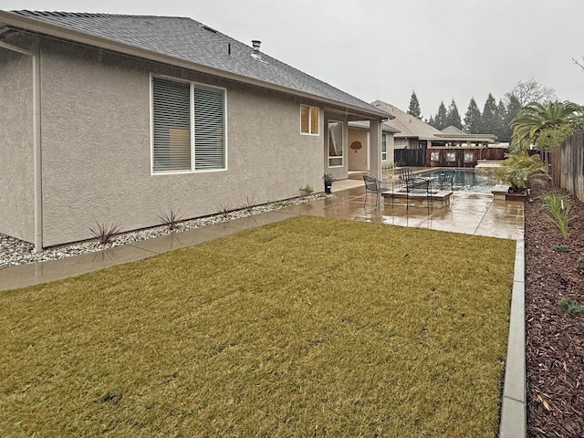 rear view of house with a fenced in pool, a yard, and a patio