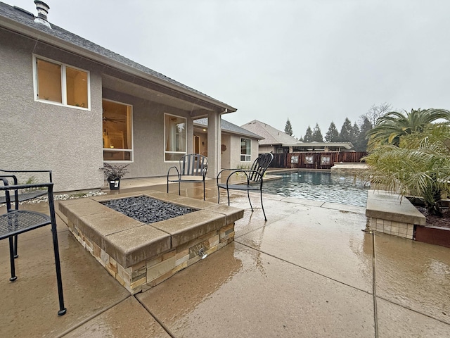 view of swimming pool with a patio and a fire pit