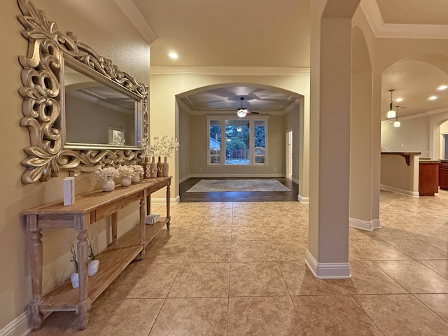 tiled entrance foyer featuring ornamental molding and ceiling fan