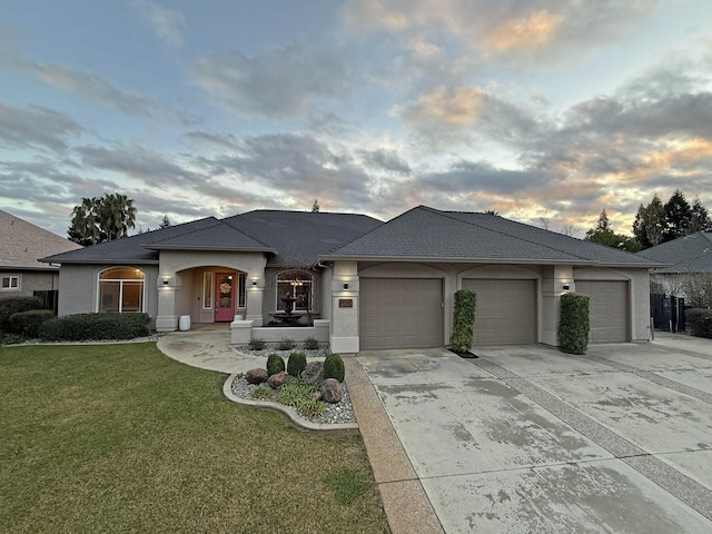 prairie-style house featuring a garage and a lawn