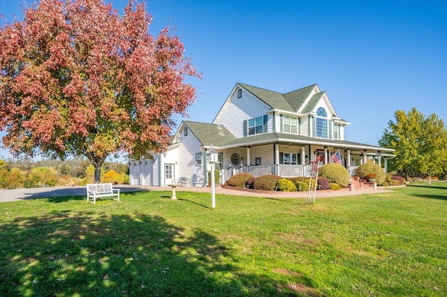 view of front of home with a garage, covered porch, and a front lawn