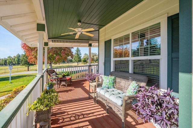 wooden deck featuring covered porch and ceiling fan