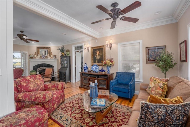 living room with crown molding, light hardwood / wood-style flooring, and ceiling fan