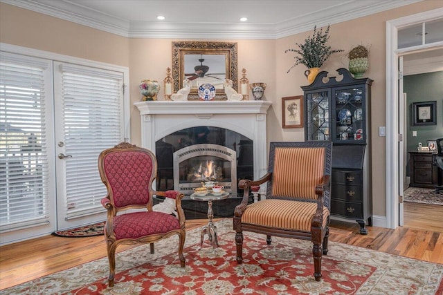 living area featuring hardwood / wood-style flooring and ornamental molding