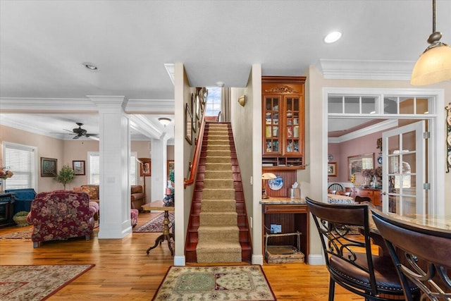 interior space featuring crown molding, hardwood / wood-style flooring, ceiling fan, and ornate columns