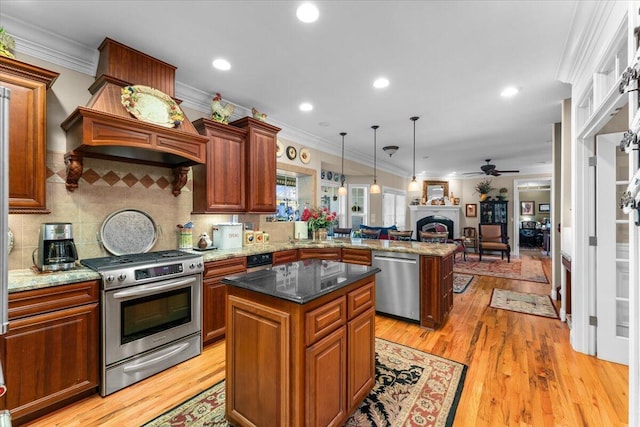 kitchen with pendant lighting, a center island, kitchen peninsula, and appliances with stainless steel finishes