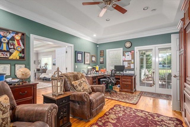 office area with french doors, ornamental molding, a raised ceiling, and light wood-type flooring