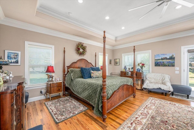 bedroom with access to exterior, ceiling fan, a tray ceiling, crown molding, and light wood-type flooring