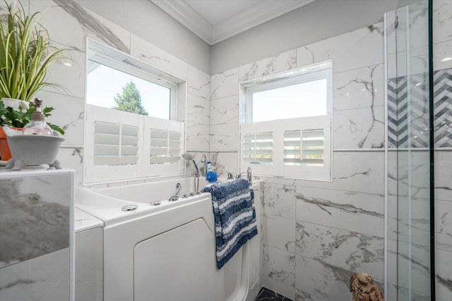 bathroom with crown molding, a bathtub, and tile walls