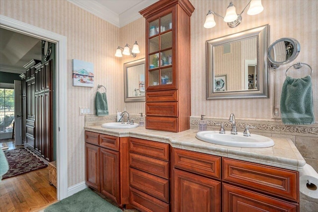 bathroom featuring crown molding, hardwood / wood-style floors, and vanity