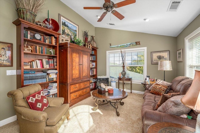 living area featuring a wealth of natural light, lofted ceiling, light carpet, and ceiling fan