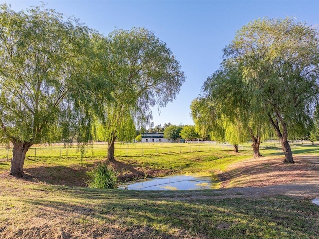 view of home's community featuring a water view, a lawn, and a rural view