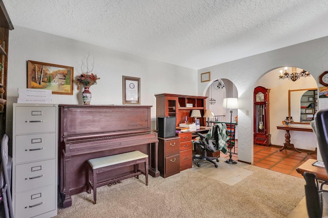 home office with light tile patterned flooring, an inviting chandelier, and a textured ceiling