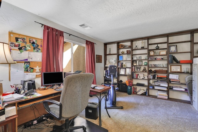 carpeted home office featuring a textured ceiling