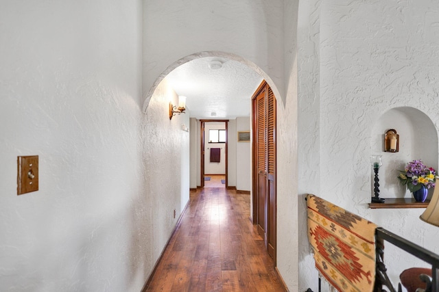 hallway featuring dark hardwood / wood-style flooring and a textured ceiling