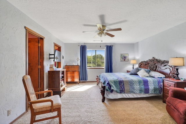 carpeted bedroom featuring ceiling fan and a textured ceiling