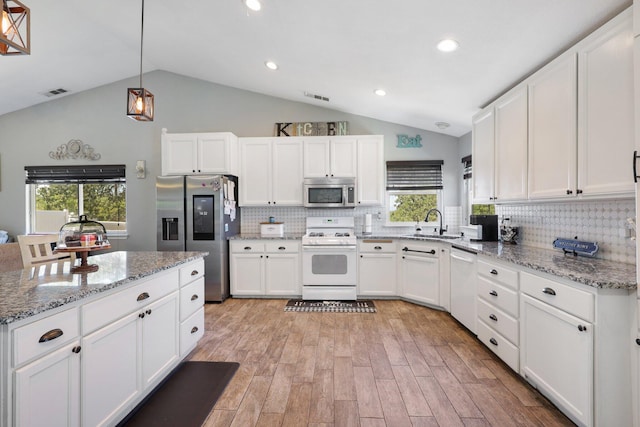 kitchen featuring white cabinetry, appliances with stainless steel finishes, light stone counters, and pendant lighting