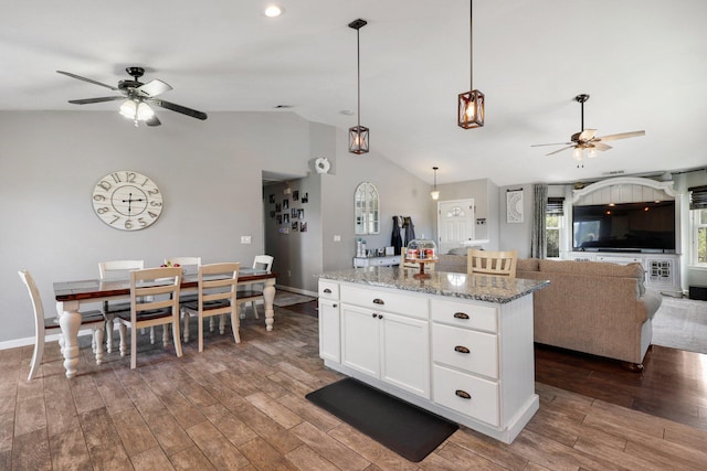 kitchen featuring dark hardwood / wood-style floors, a kitchen island, ceiling fan, light stone countertops, and white cabinets