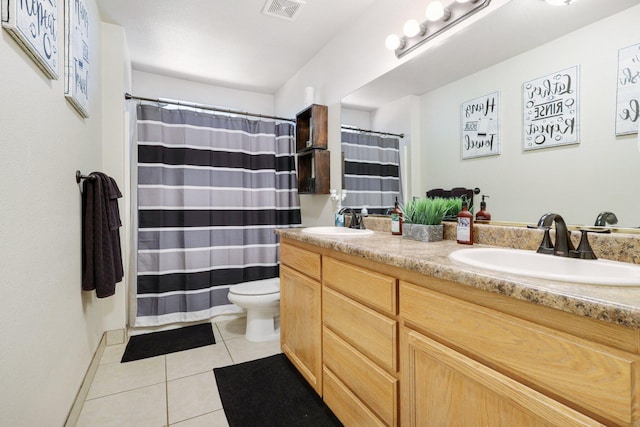 bathroom with tile patterned flooring, vanity, and toilet