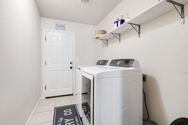 washroom featuring light tile patterned floors and washer and clothes dryer