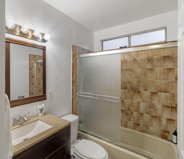 full bathroom with vanity, enclosed tub / shower combo, and toilet